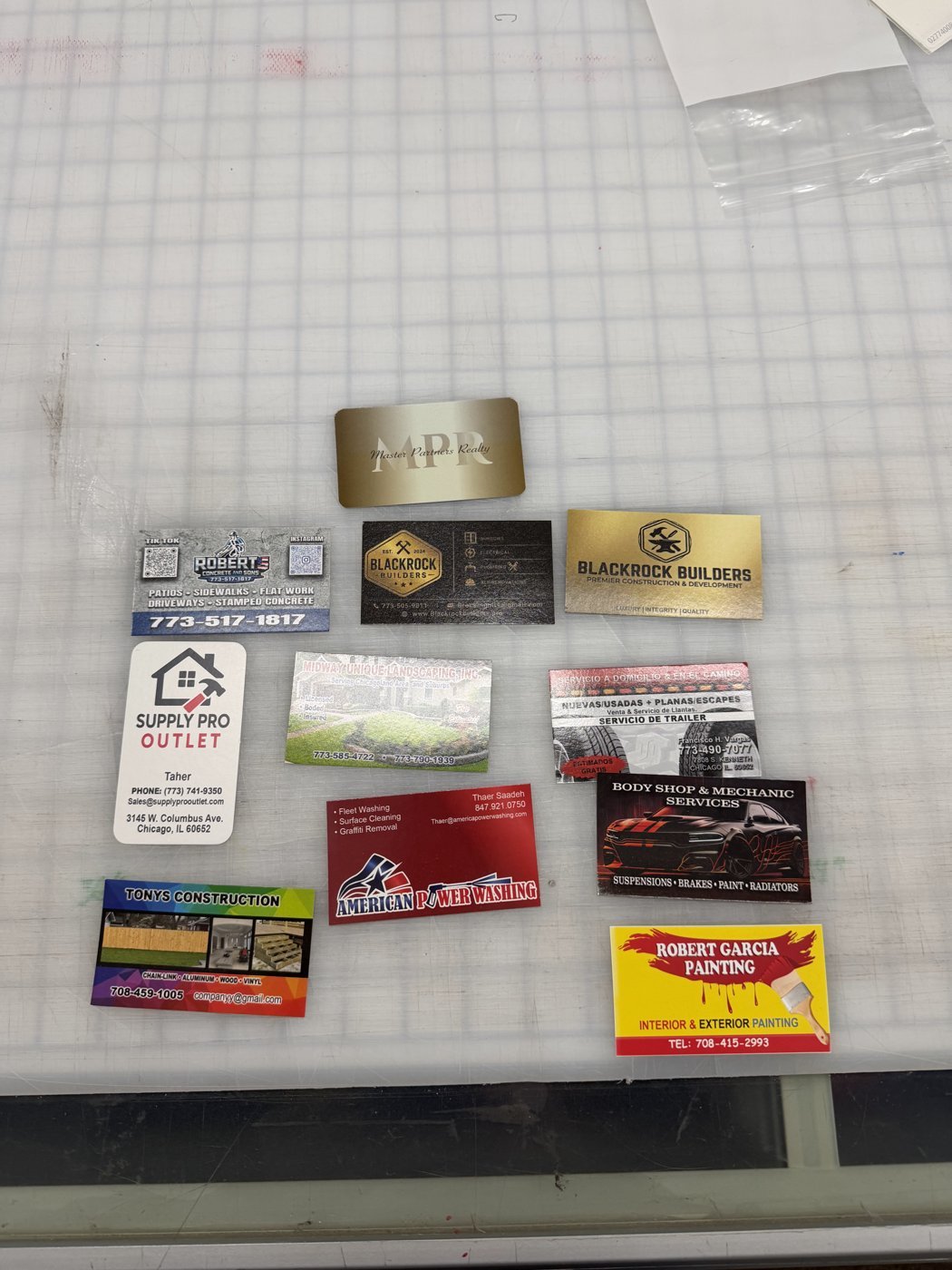 A spread of printed business cards for local Chicago businesses, including gold and full-color designs