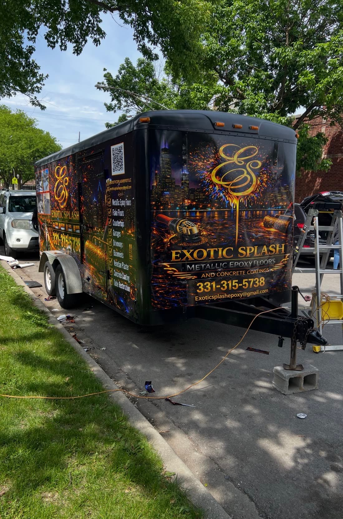 Black trailer wrapped in gold and blue graphics for an epoxy flooring company